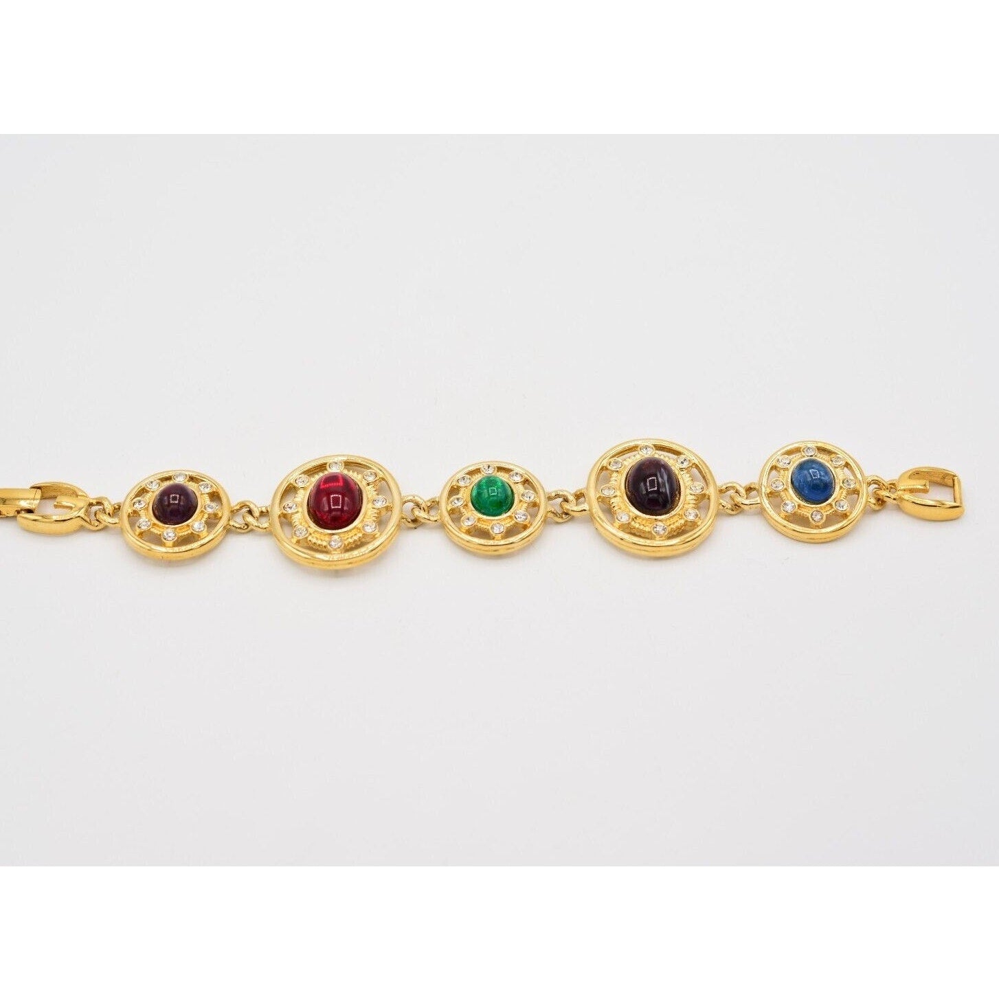 Gold bracelet with colorful gemstones on a white background