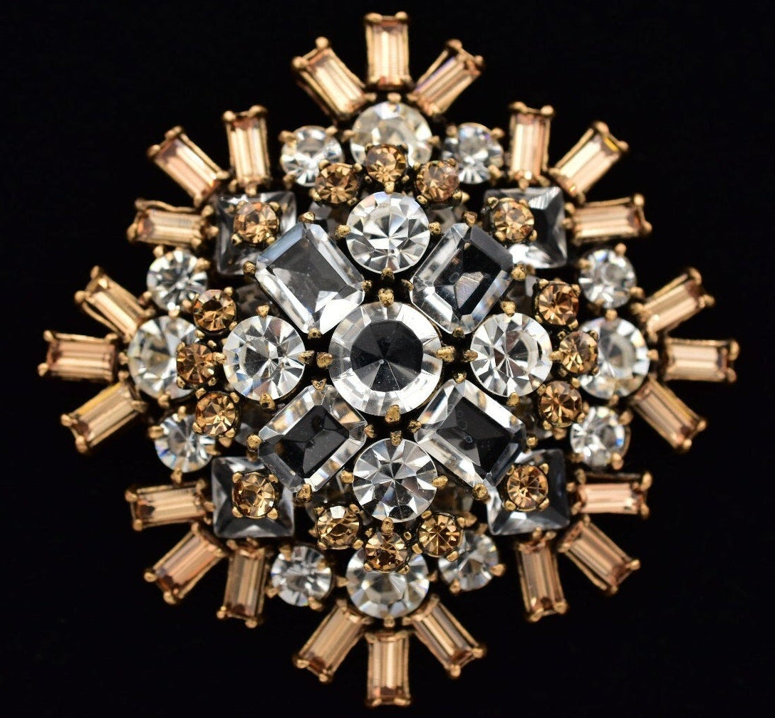 Decorative brooch with crystals on a black background. 