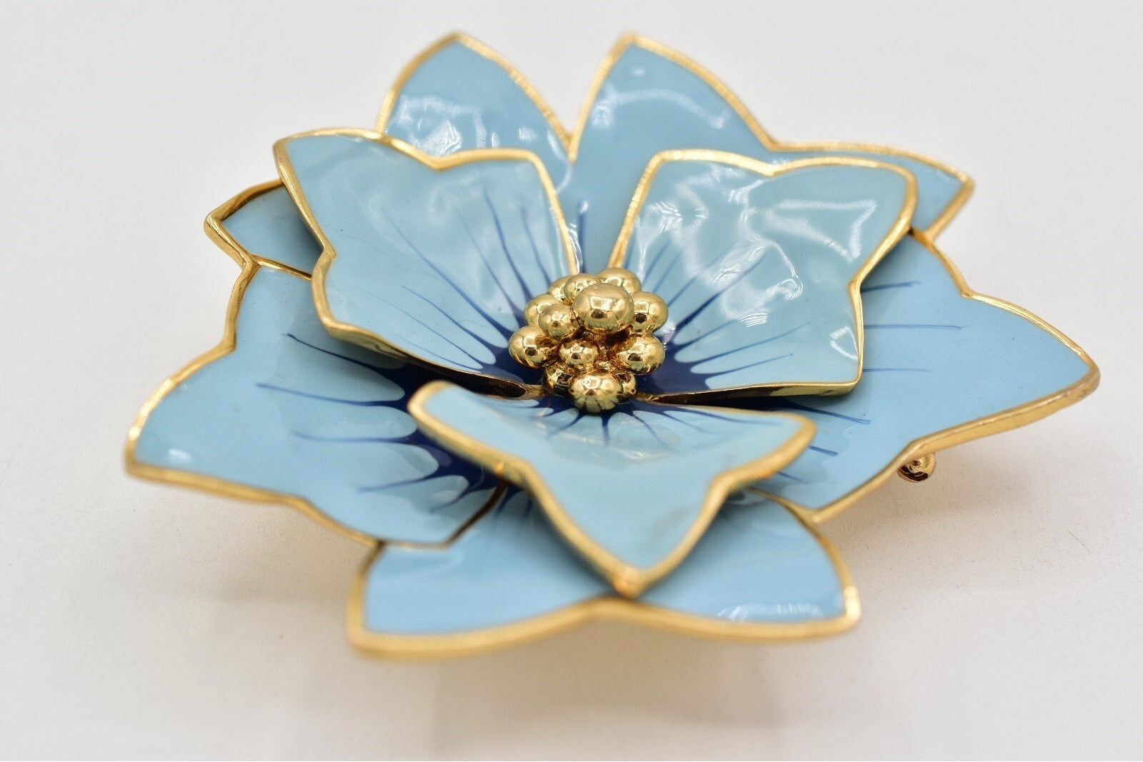 Blue flower-shaped object with gold accents on a white background