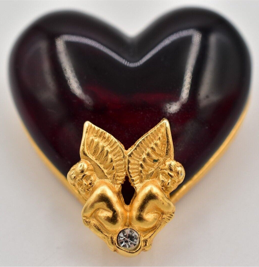 A vintage Givenchy Gripoix heart-shaped brooch with gold cherubs detail.