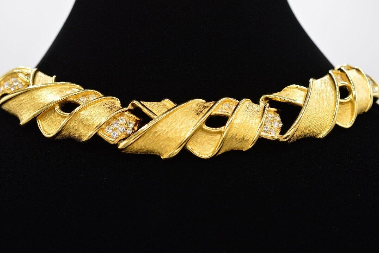 Gold necklace with diamond accents on a black background