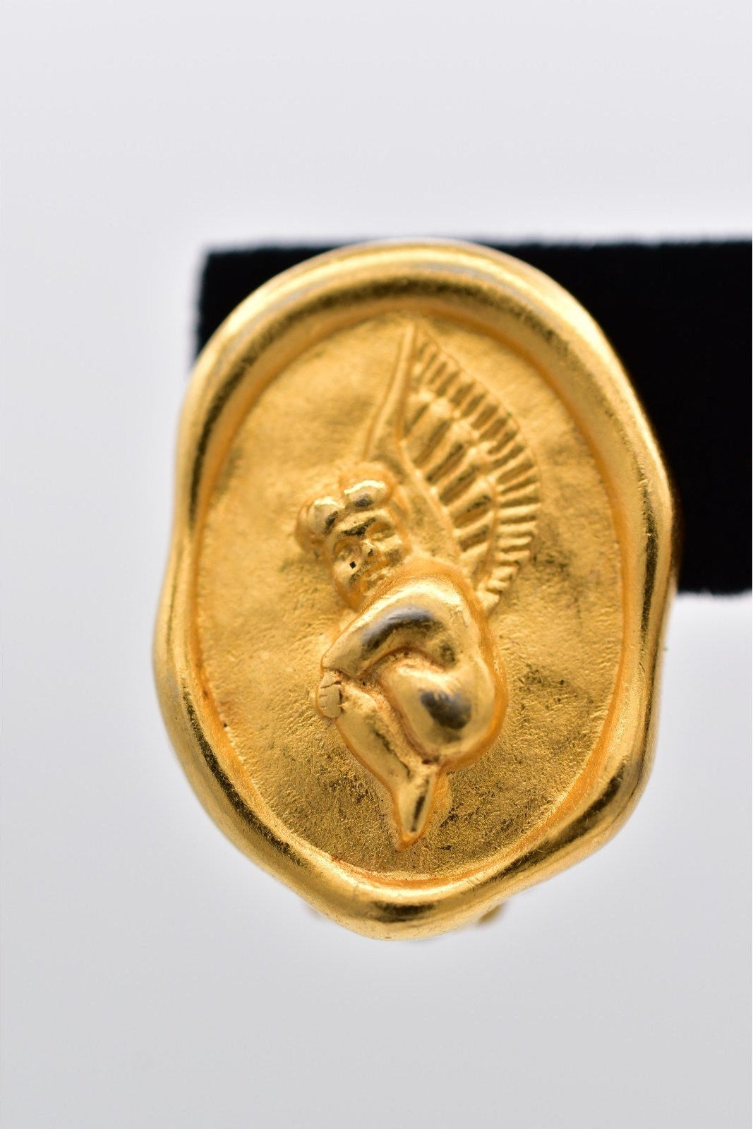 Gold ring with a engraved design on a white background