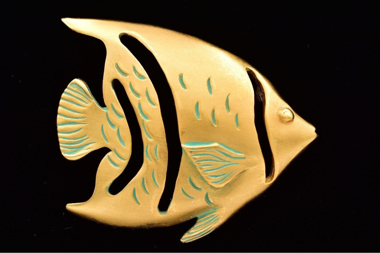 Gold fish-shaped object on a black background