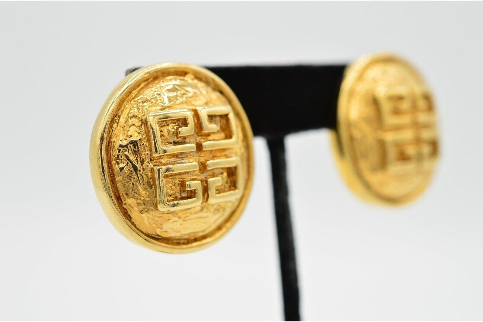 Pair of gold earrings with a geometric design on a white background