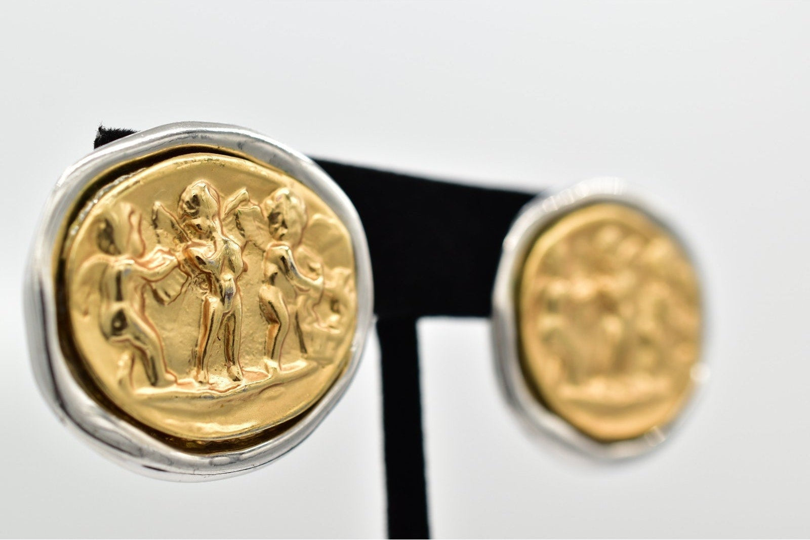 Gold and silver earrings with intricate designs on a white background