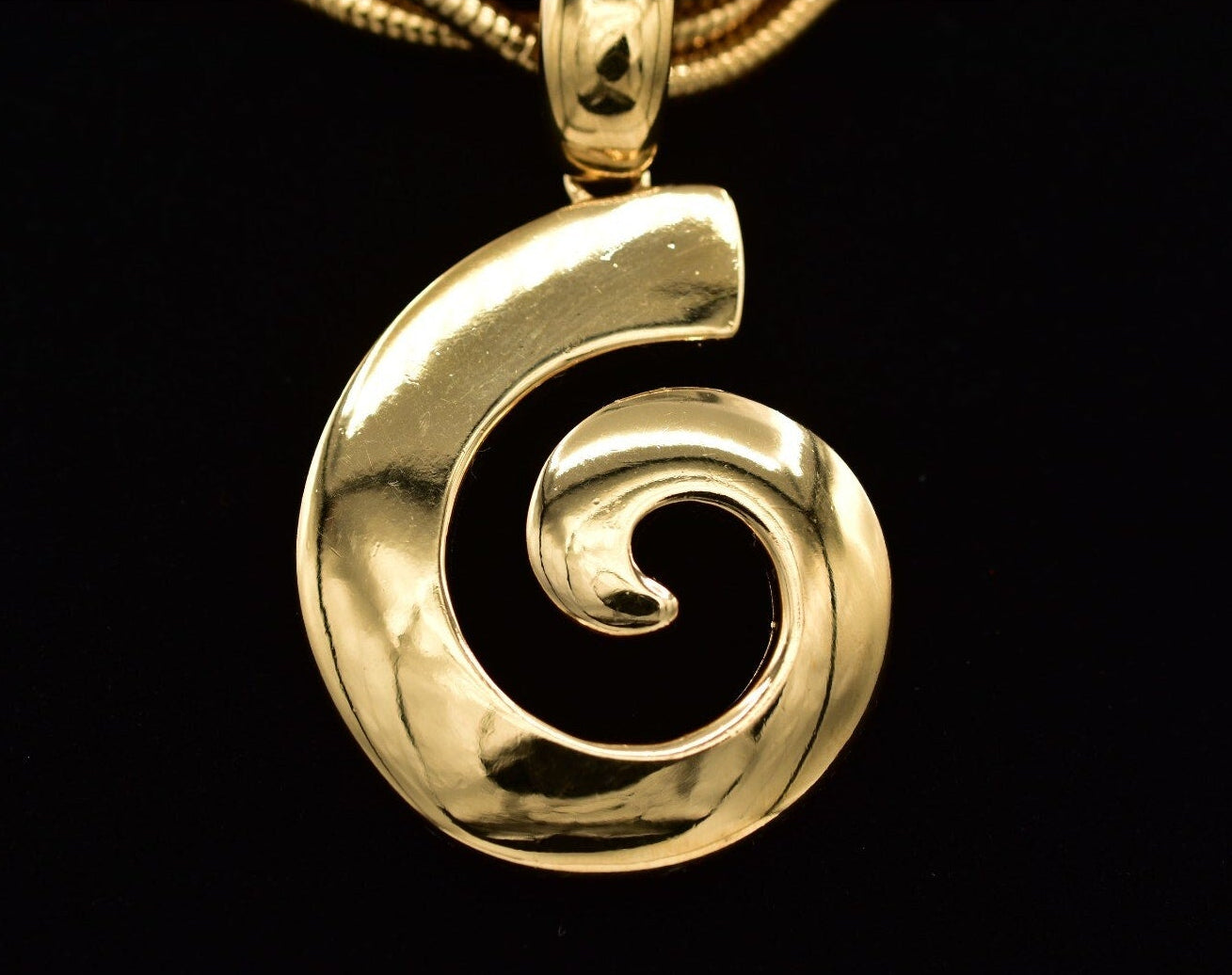 Gold spiral pendant on a black background