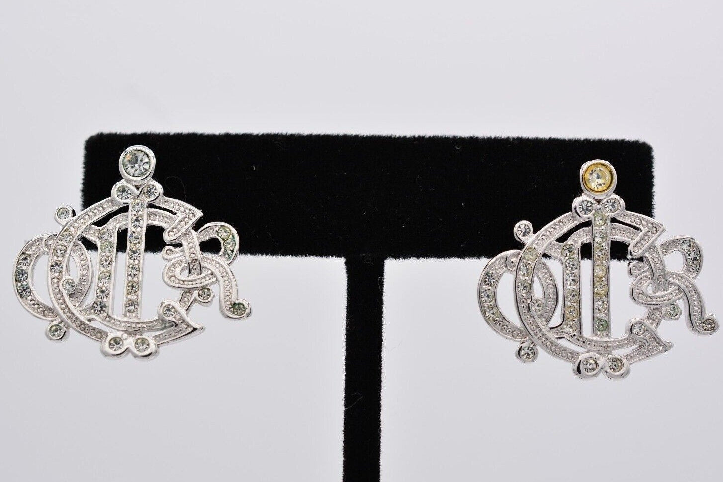 Pair of silver earrings with intricate designs on a black and white background