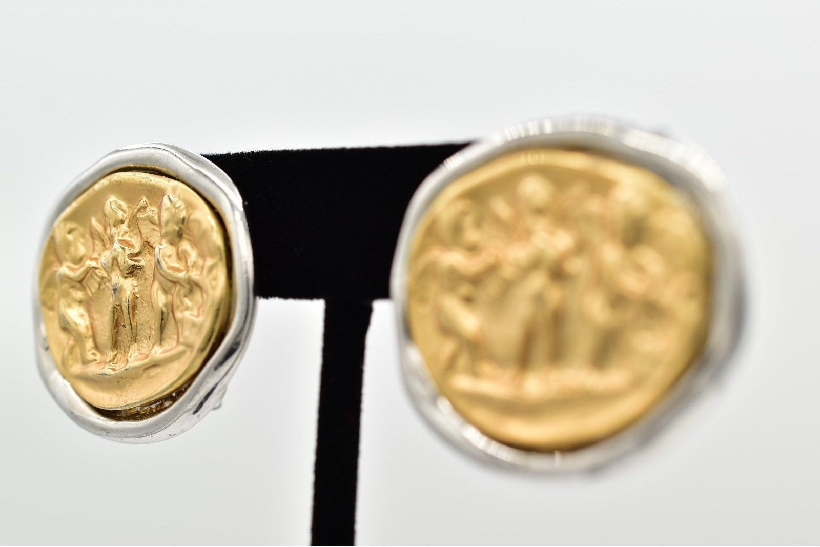 Pair of gold coin earrings on a white background