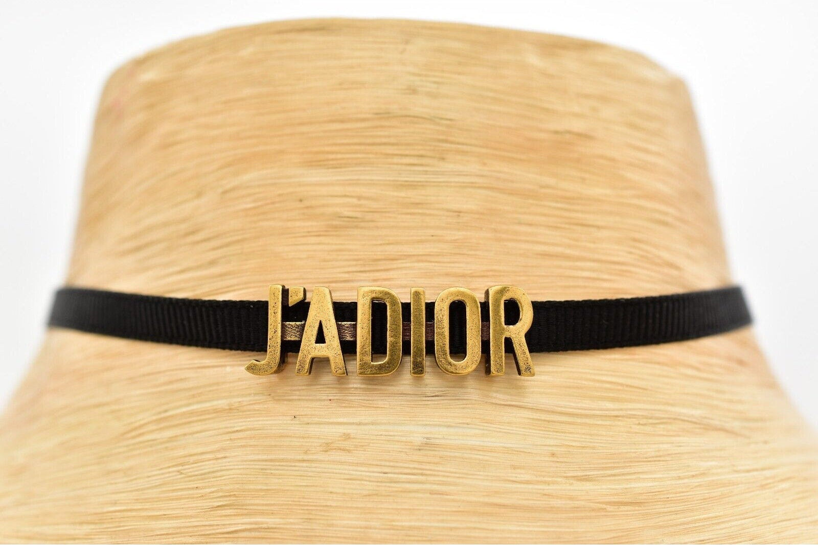 Straw hat with 'J'adior' band on a white background