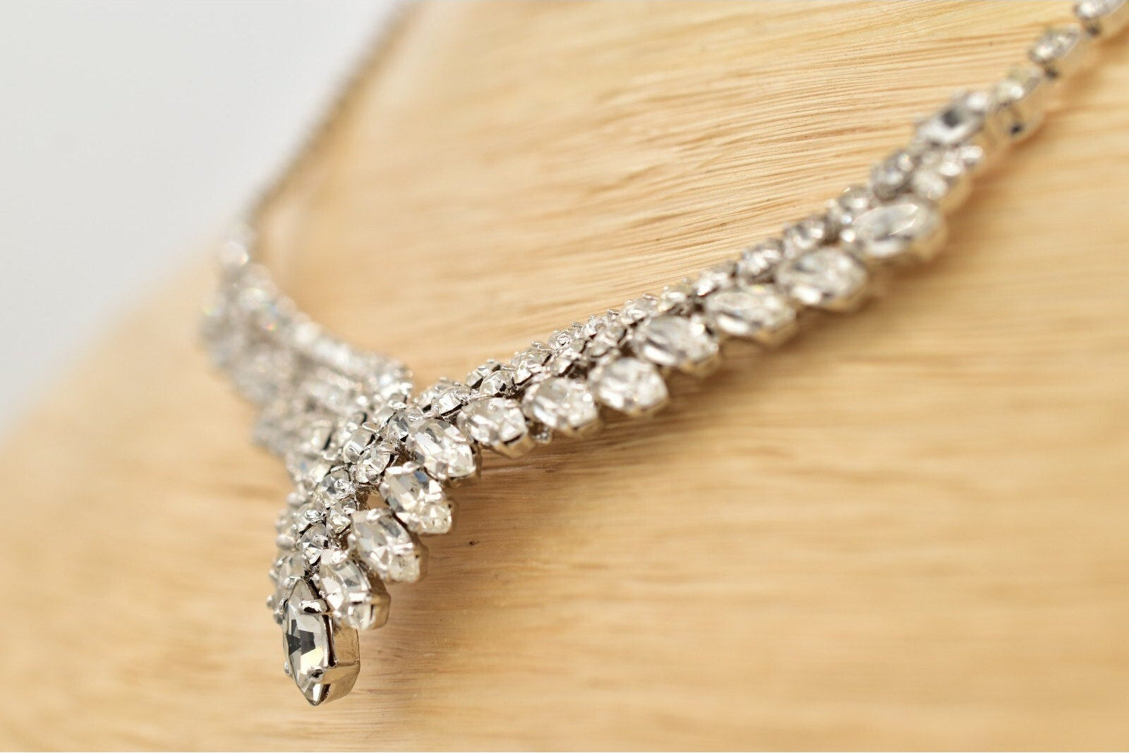 Silver necklace with clear stones on a wooden surface