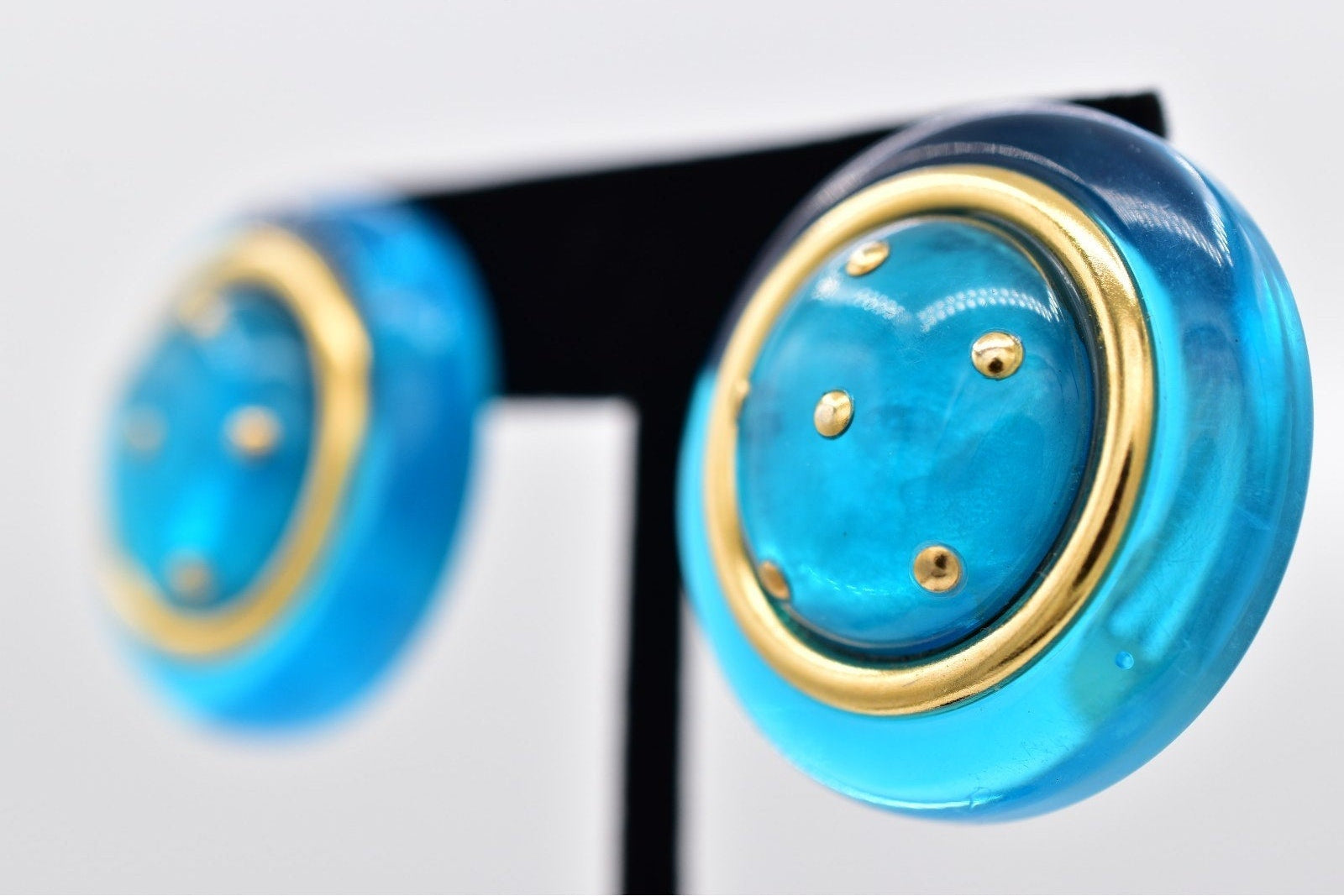 Close-up of blue and gold earrings on a white background