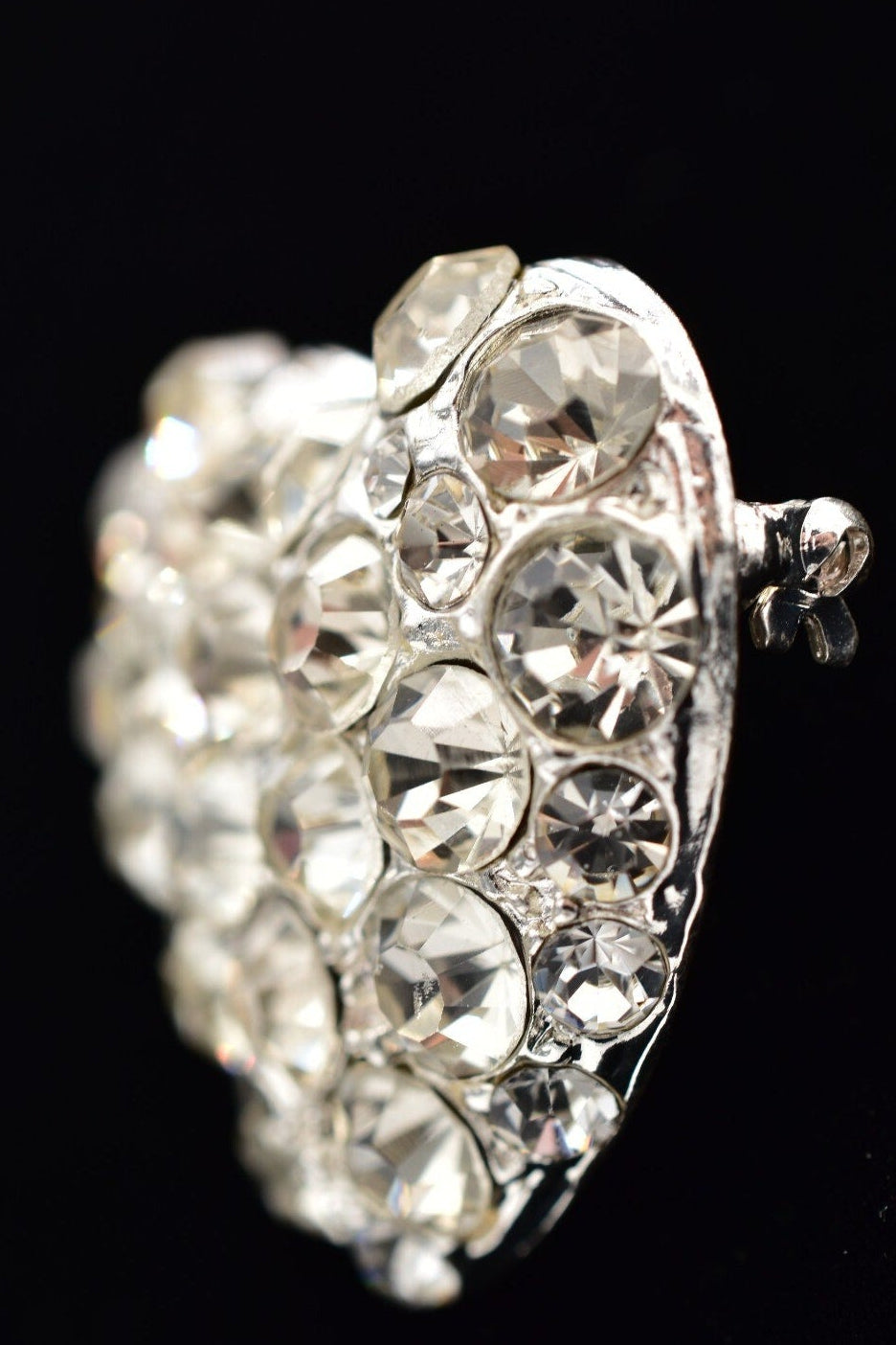 Silver ring with clear gemstones on a black background