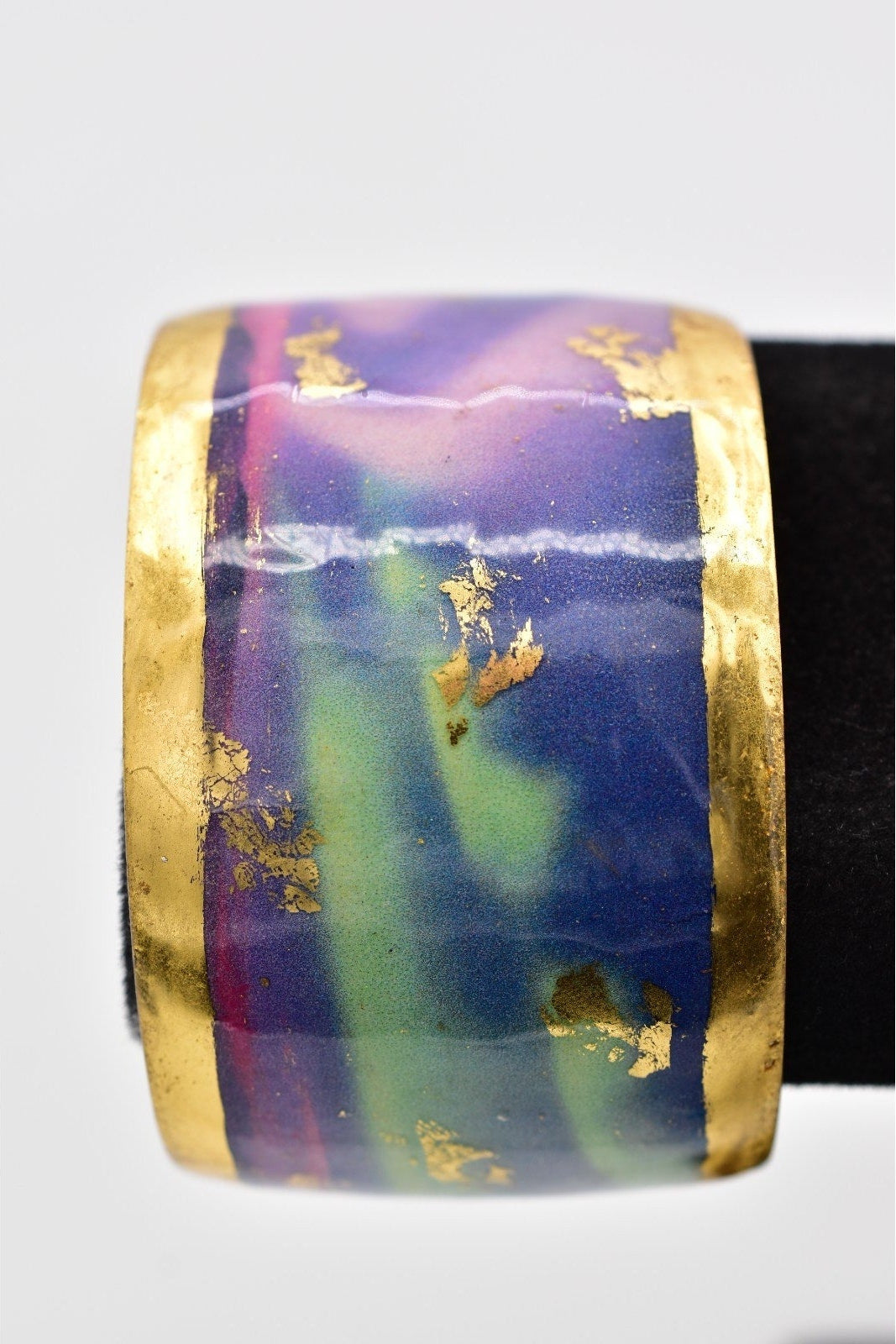 Multicolored bangle with gold accents on a white background