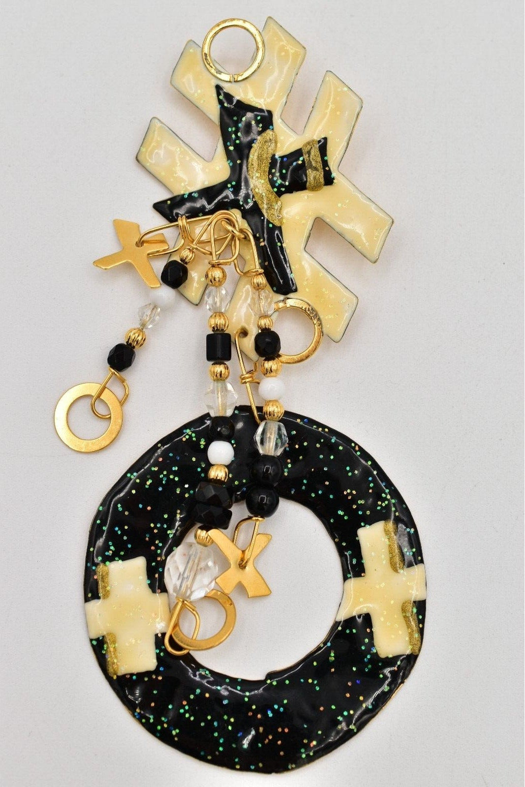 Tic Tac Toe brooch with gold and black elements on a gray background