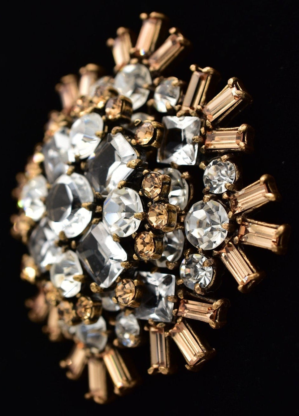 Jewelry ring with clear and gold gemstones on a black background