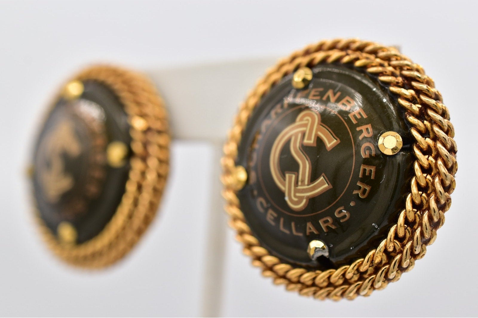 Gold and black cufflinks with 'Lenberger Cellars' branding on a white background