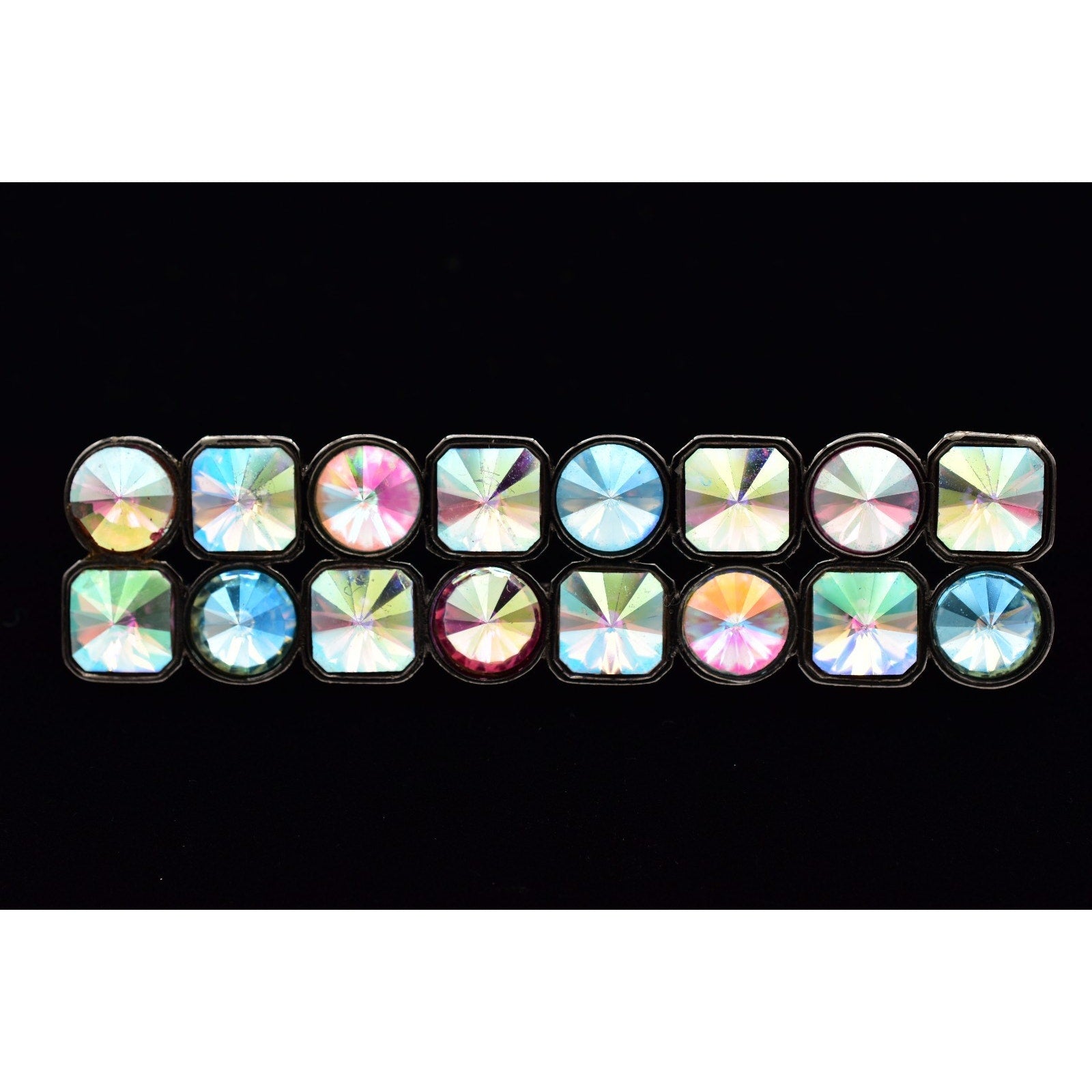 Multicolored gemstone-like objects arranged in a grid on a black background