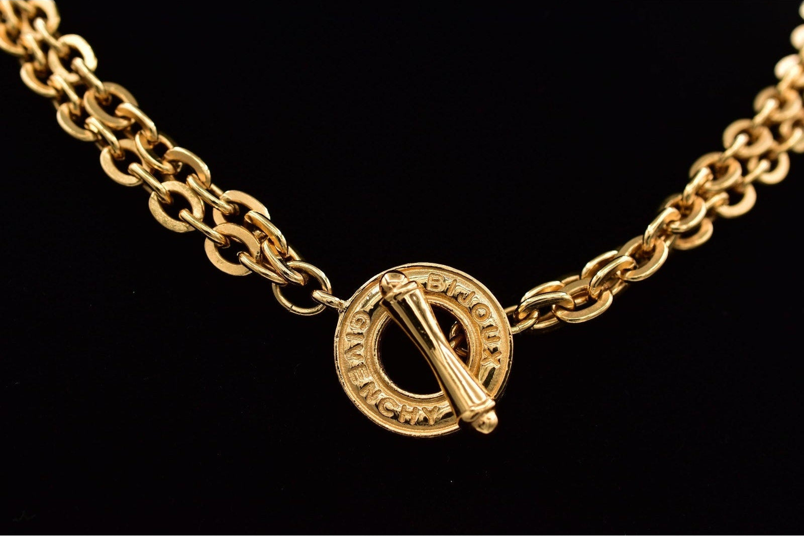 Gold chain necklace with a clasp on a black background