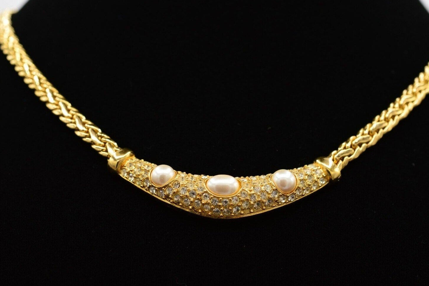 Gold necklace with pearls on a black background