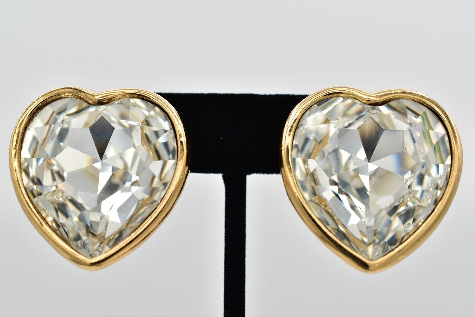 Heart-shaped earrings with clear gemstones on a white background