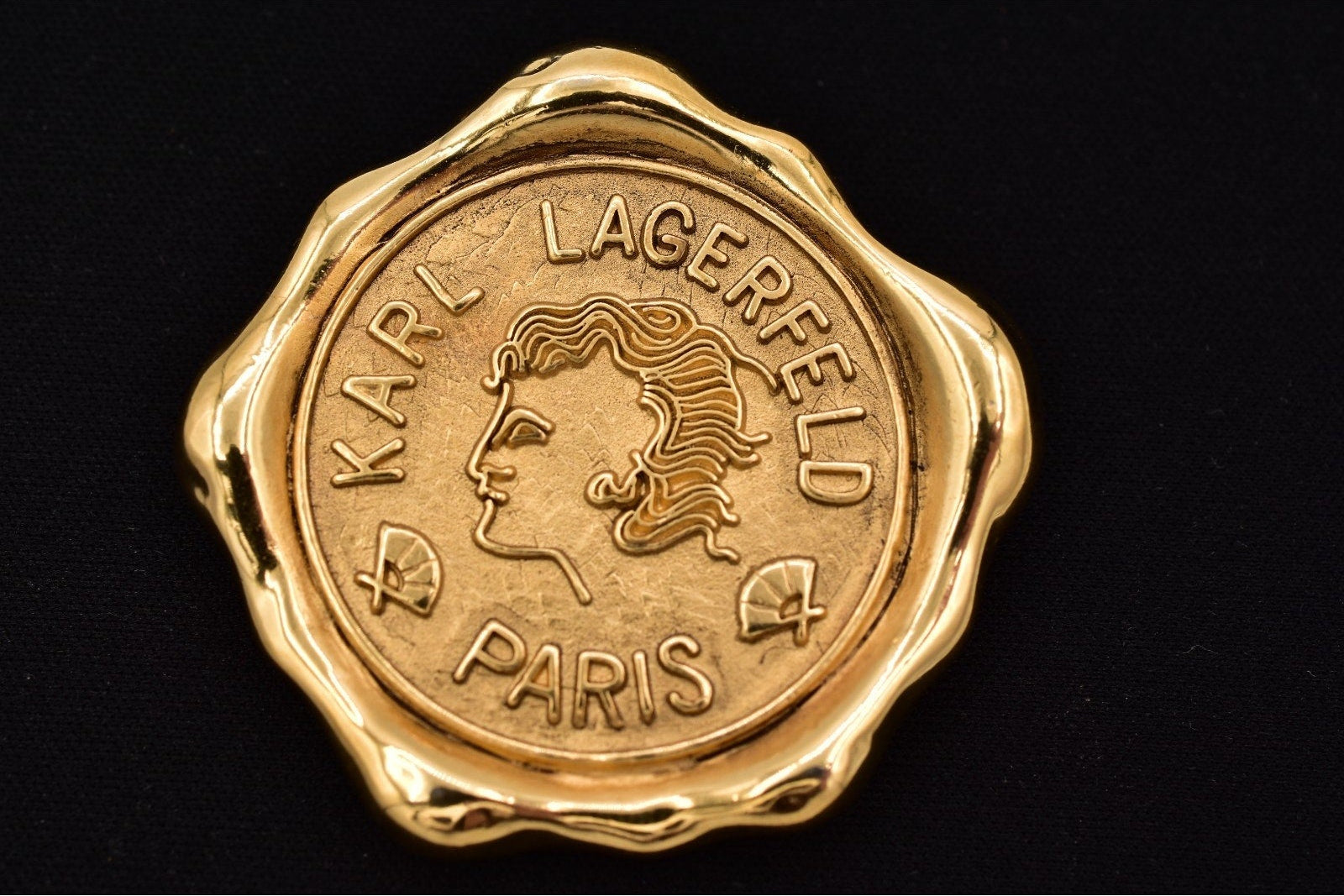 Gold emblem with Karl Lagerfeld logo on a black background