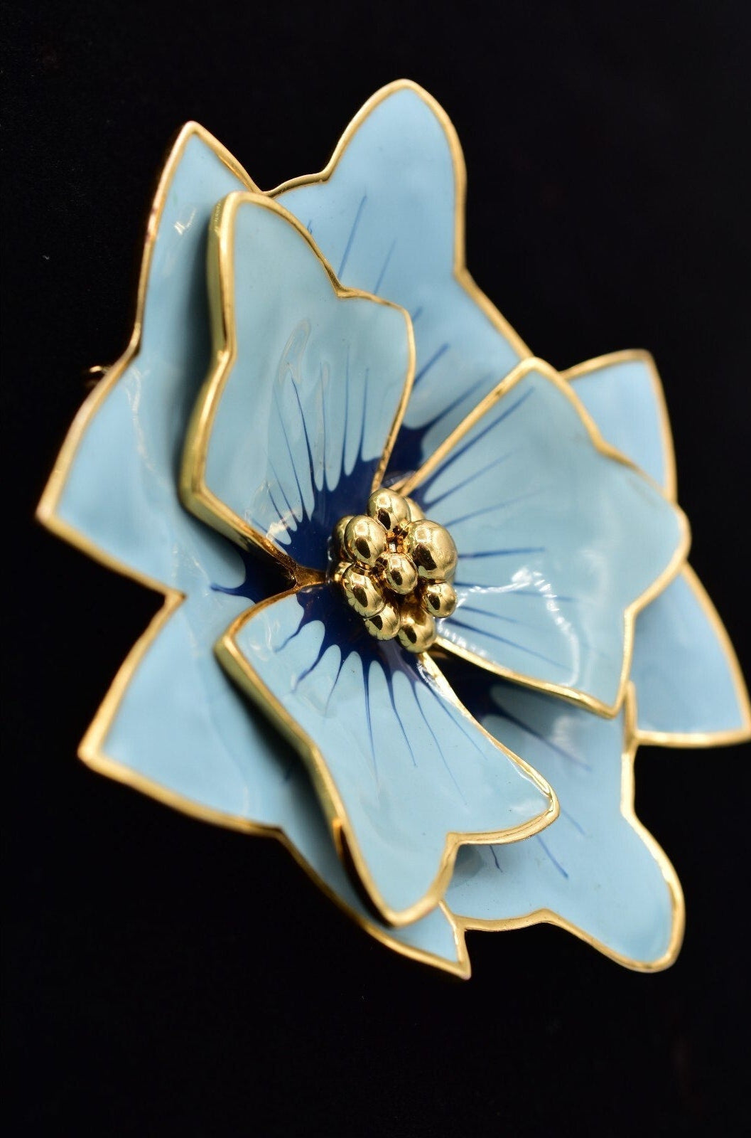 Blue flower-shaped object with gold accents on a black background