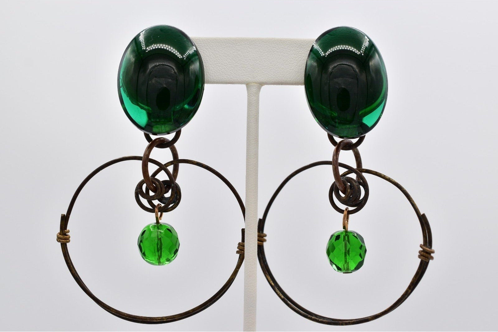 Pair of earrings with green gemstones on a white background