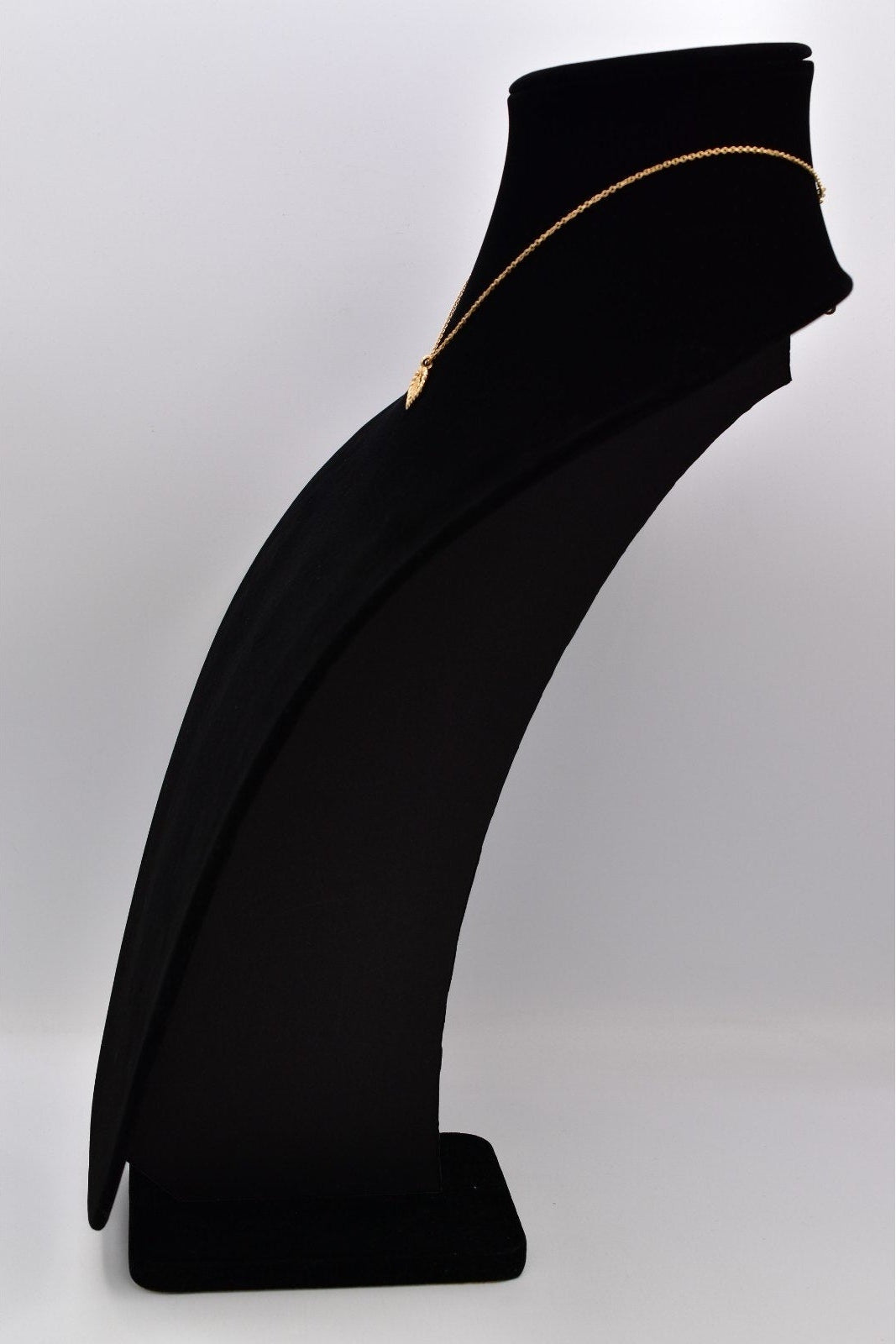 Vintage gold tone Christian Dior necklace on a black mannequin bust against a white background