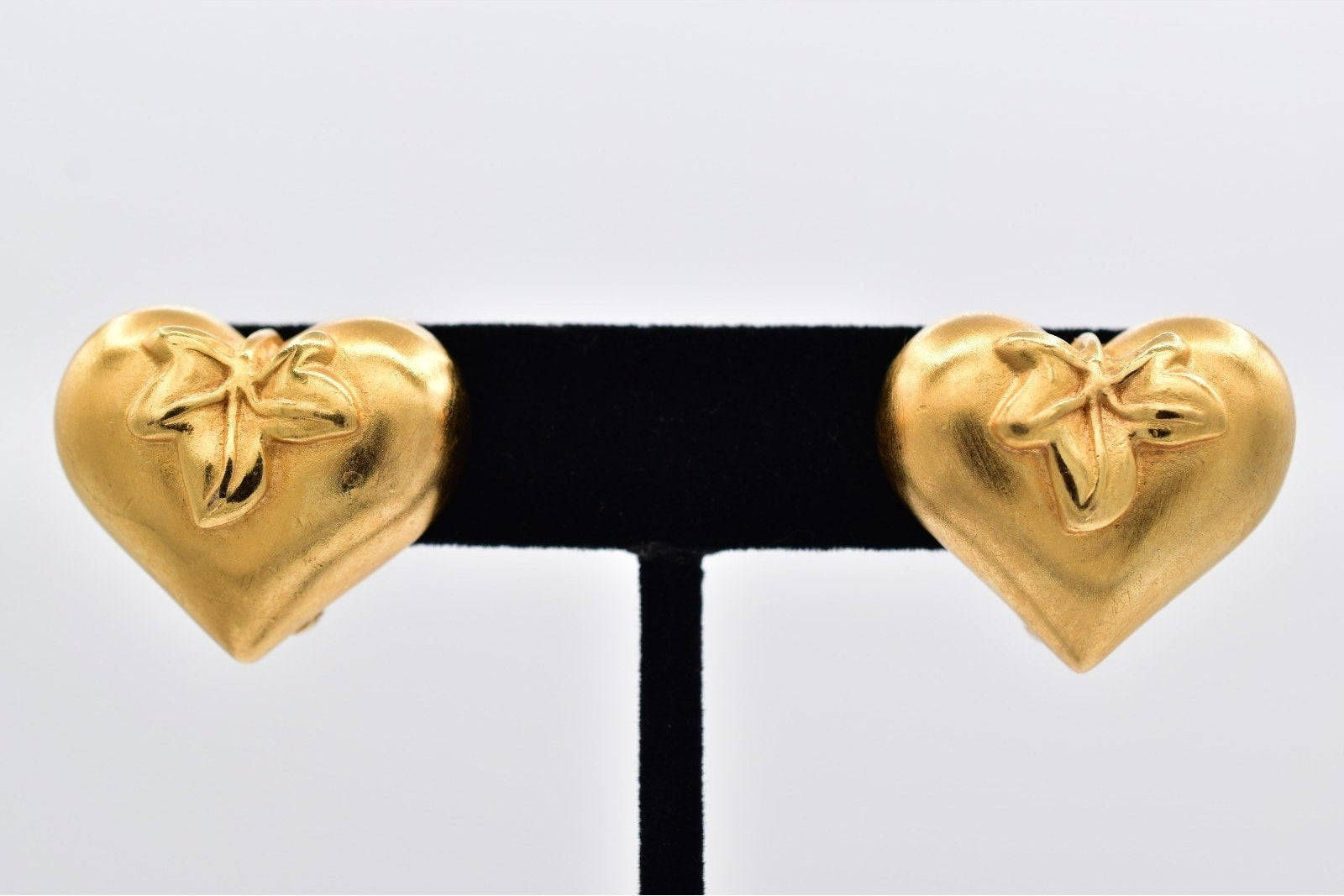 Gold heart-shaped earrings on a white background