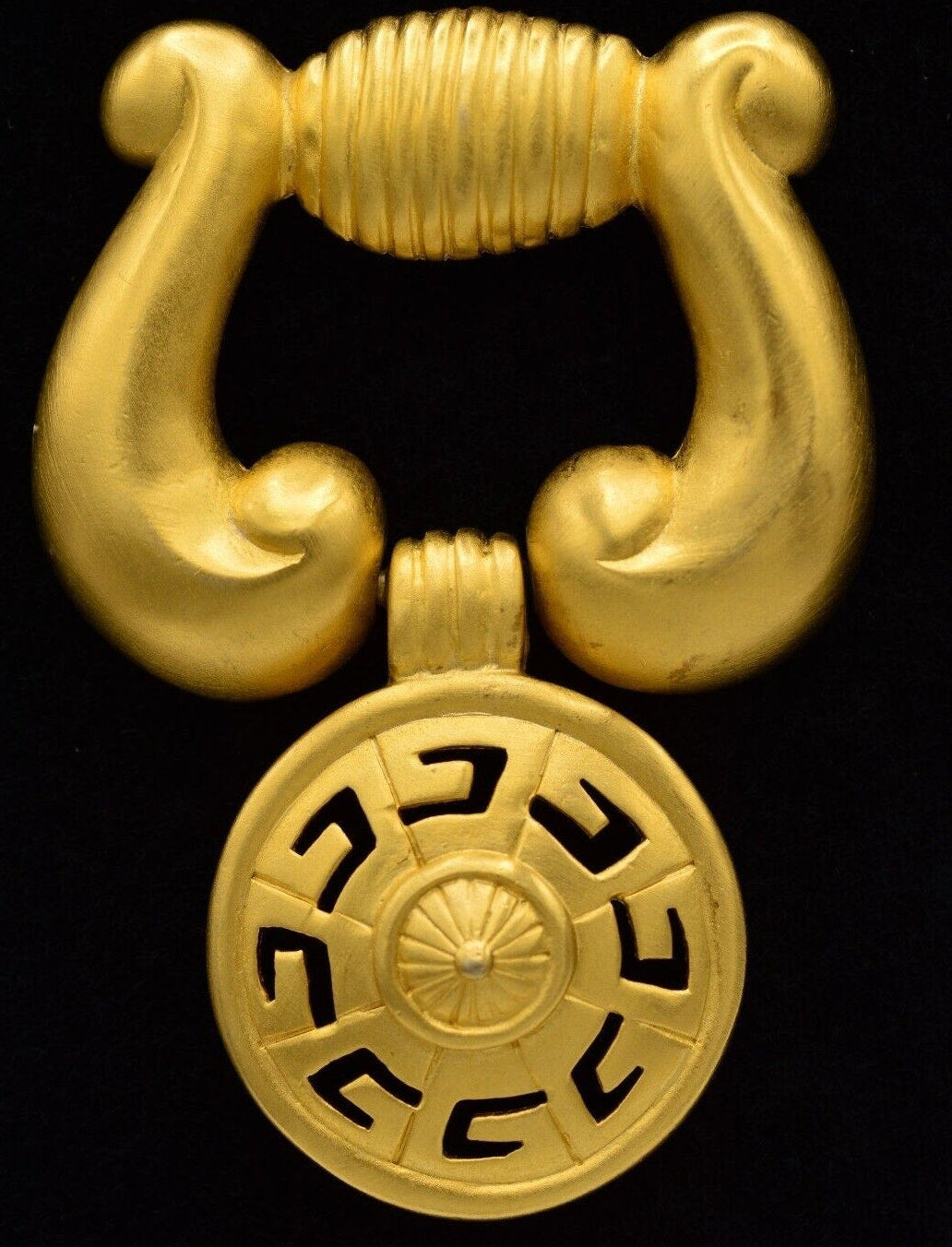 Vintage Givenchy door knocker brooch on a black background