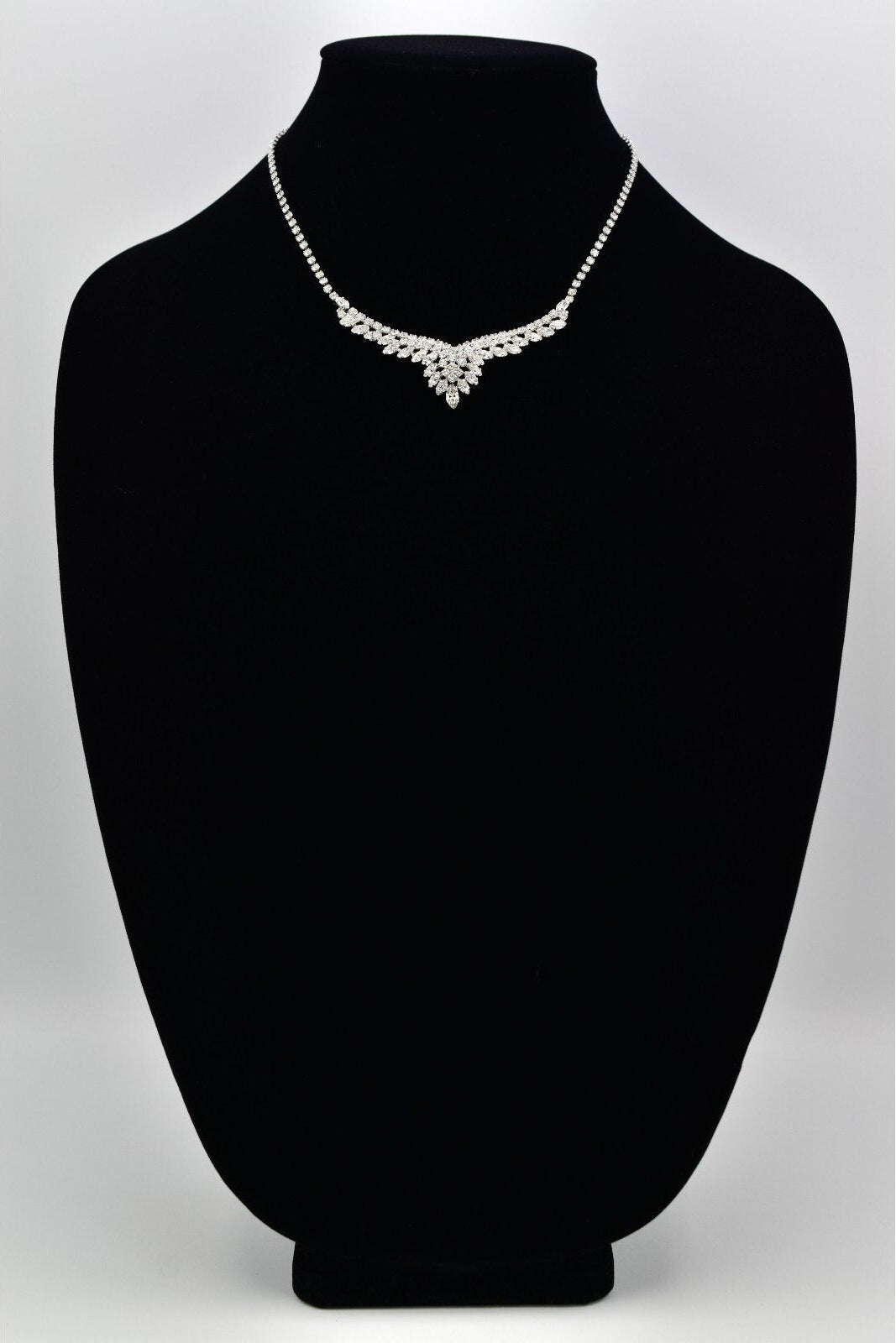 Silver Christian Dior rhinestone necklace on a black mannequin bust against a white background