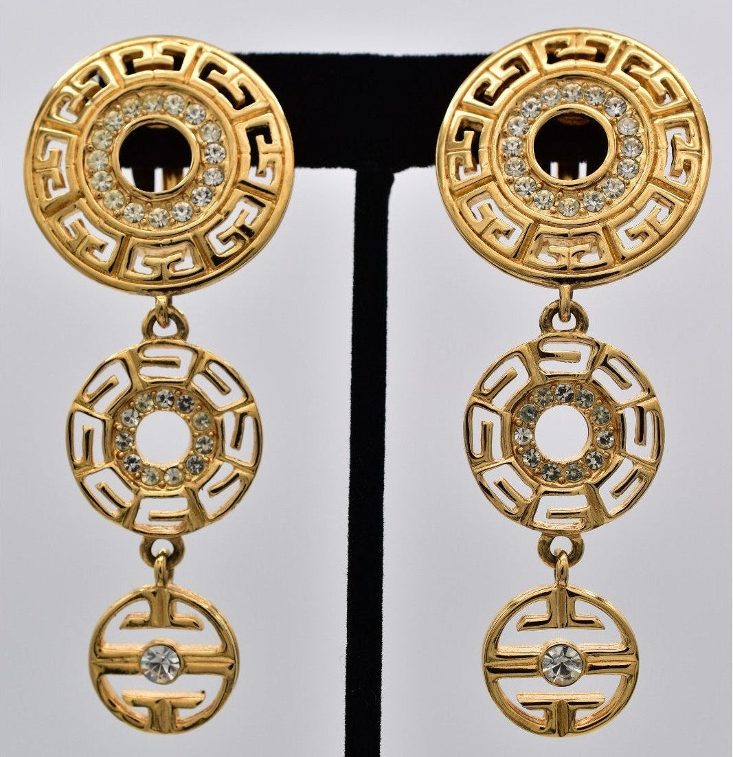 Gold earrings with intricate designs on a white background