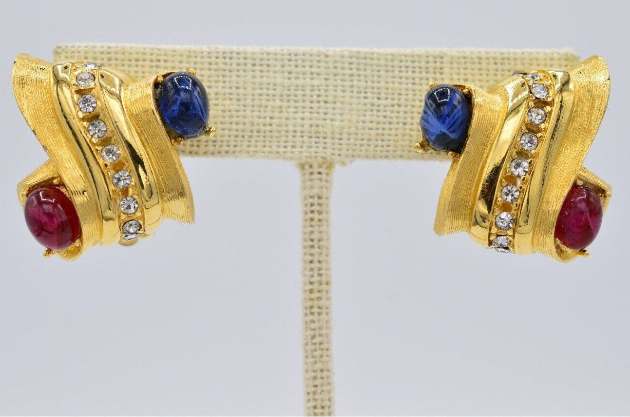 Pair of gold Givenchy earrings with gemstones on a gray background