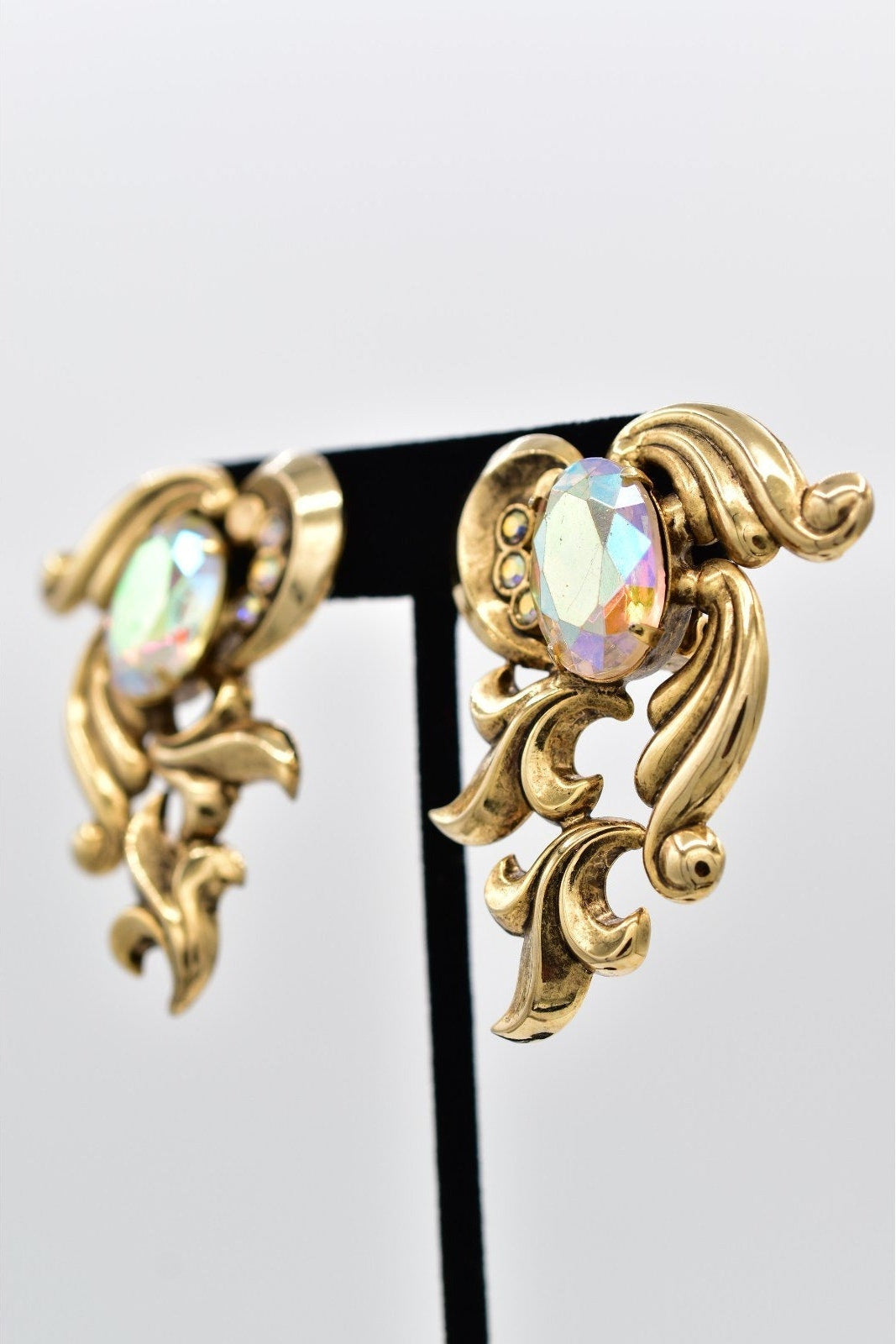 Gold earrings with colorful gemstones on a white background