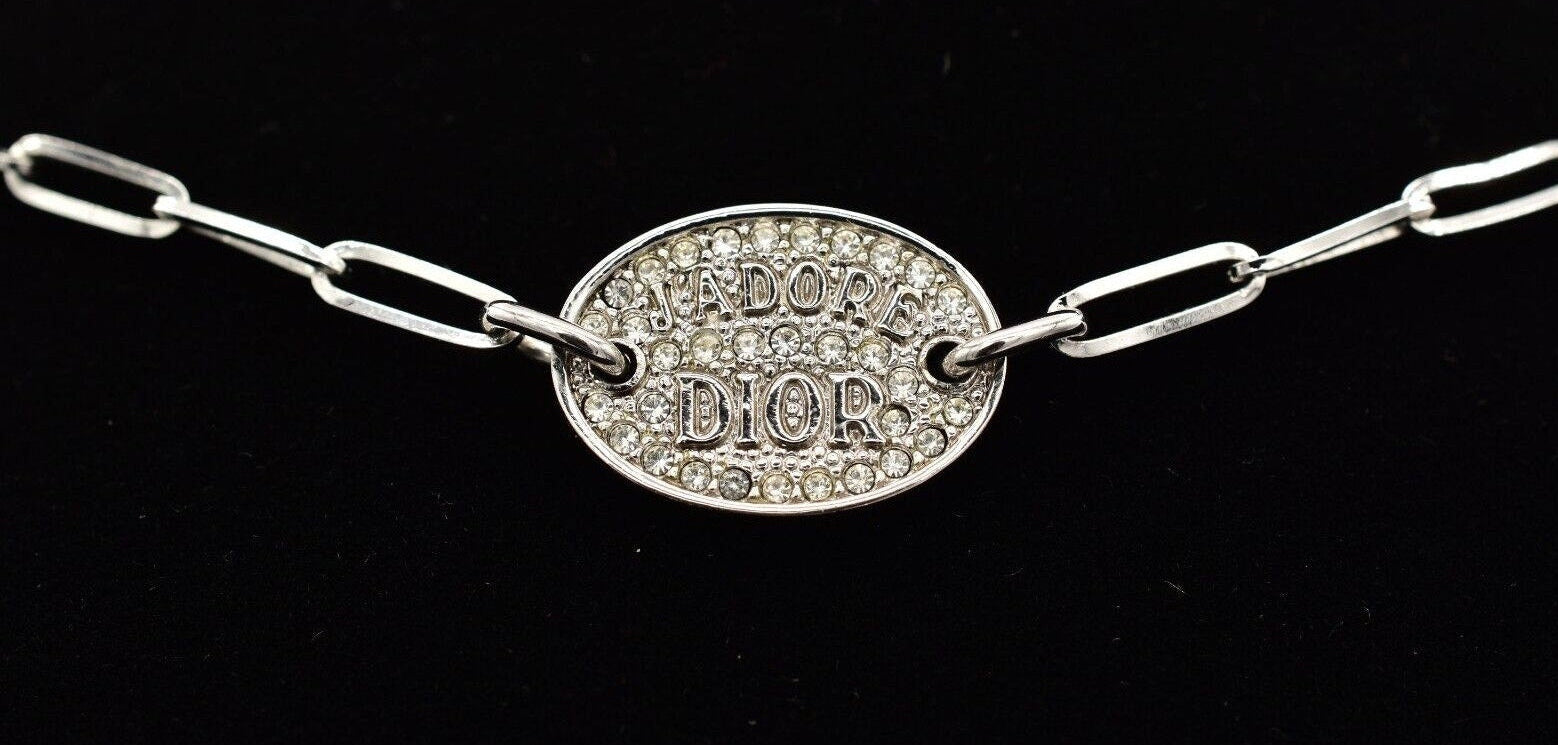 Dior J'Adore silver ID necklace with Dior plaque on a black background