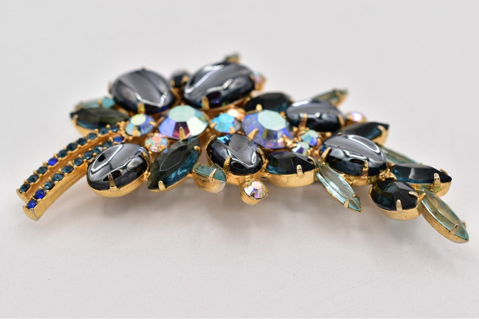 Decorative brooch with gemstones on a light gray background