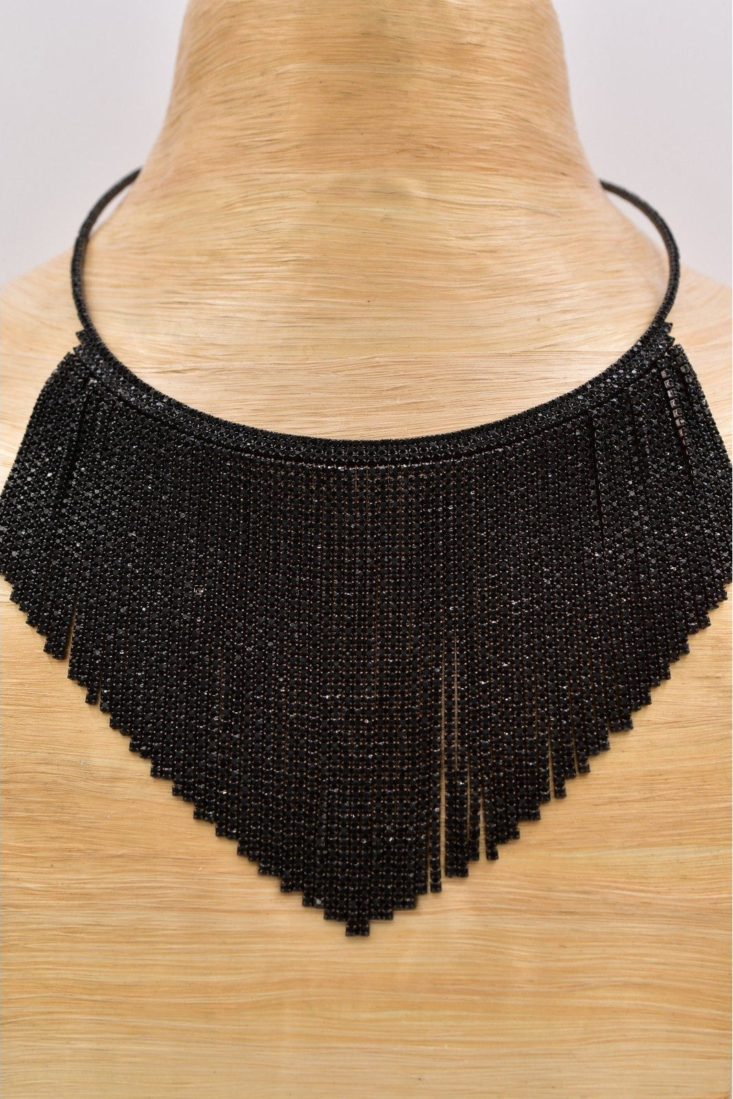 Black beaded fringe necklace on a mannequin neck against a white background