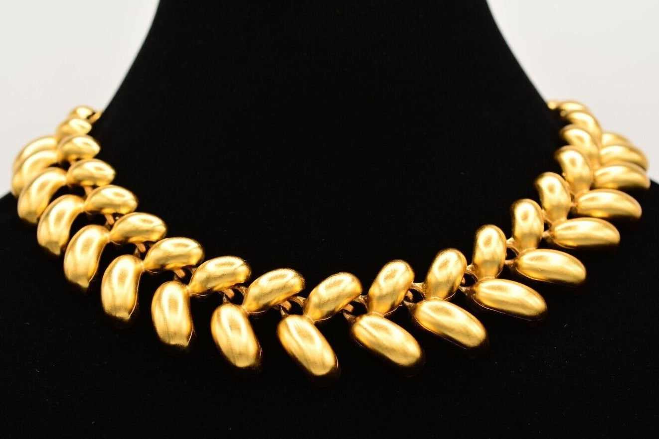 Gold necklace on a black mannequin bust