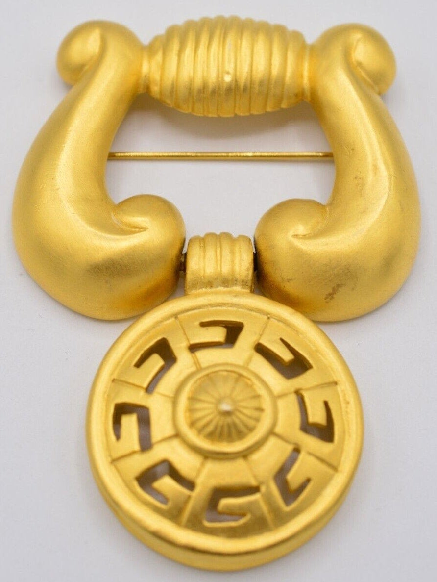 Vintage Givenchy door knocker brooch on a white background