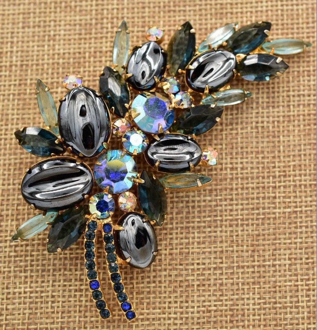 Decorative brooch with gemstones on a textured beige background