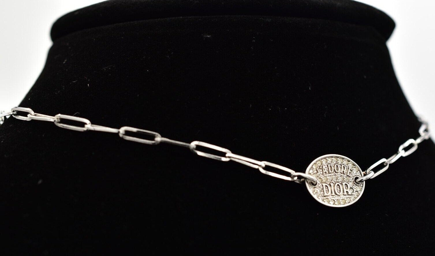 Vintage Dior J'Adore silver chain necklace with a round pendant on a black mannequin.
