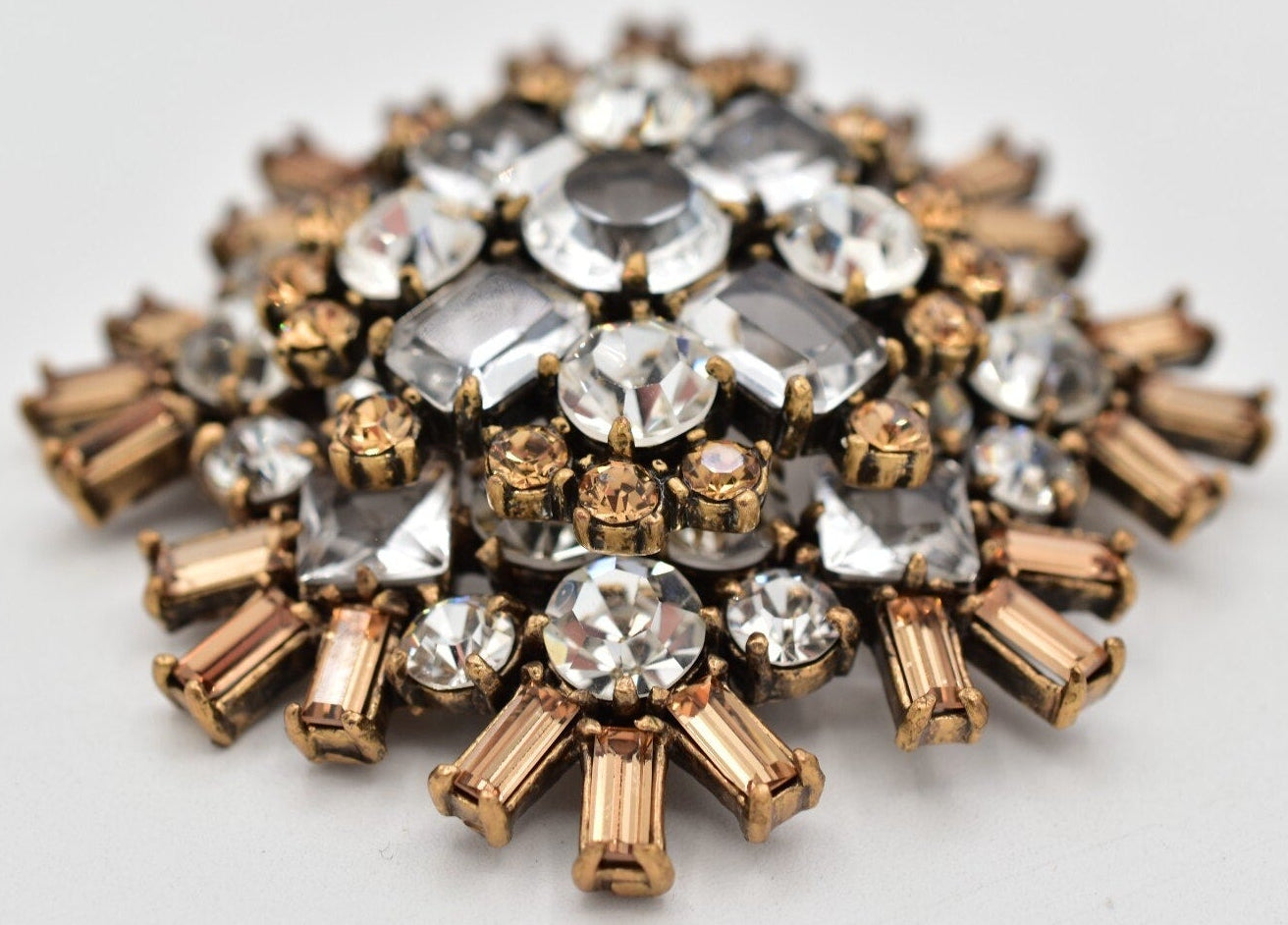 Jeweled brooch with clear and rose gold stones on a white background