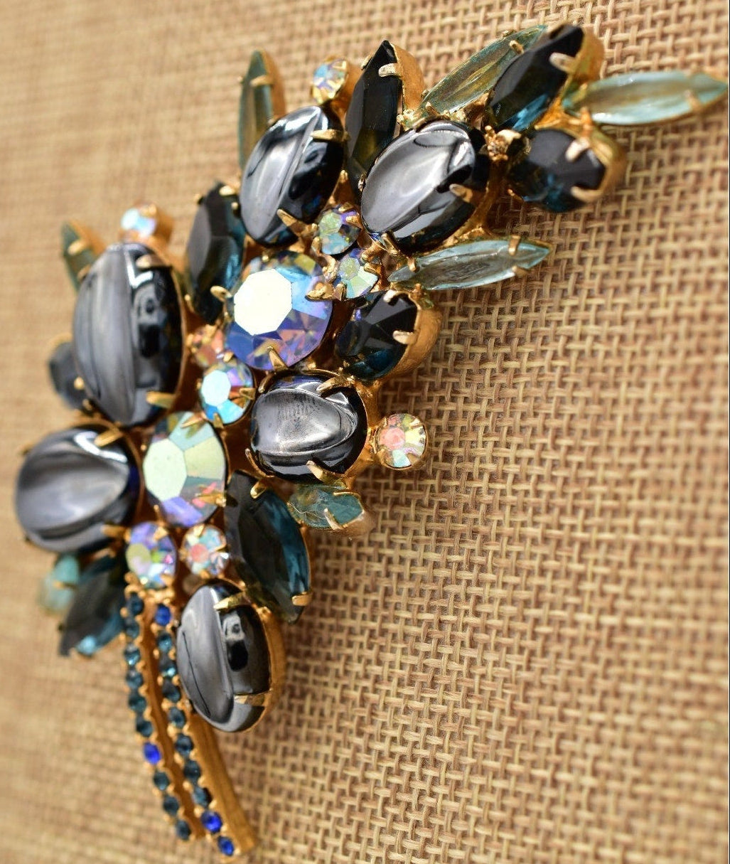 Decorative brooch with gemstones on a textured beige background
