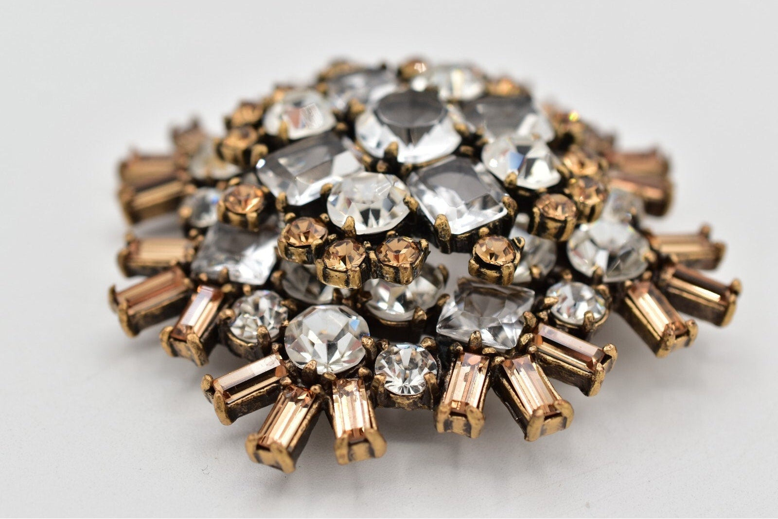 Decorative brooch with crystal-like stones on a light gray background