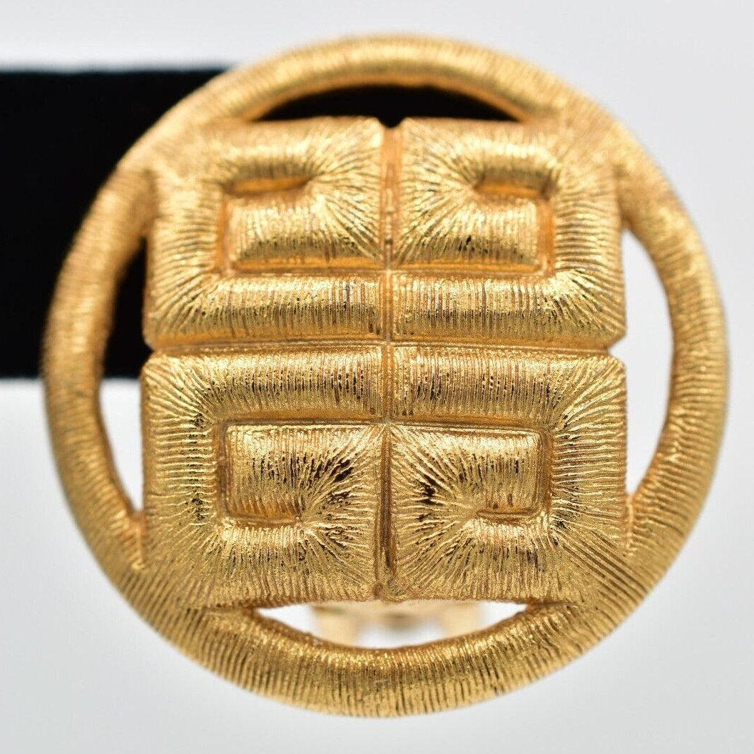 Gold earring with a textured design on a white background