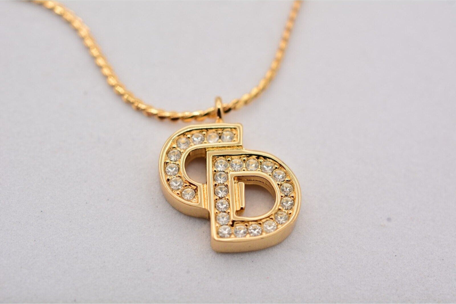 Close up view of a vintage gold Christian Dior rhinestone encrusted CD charm