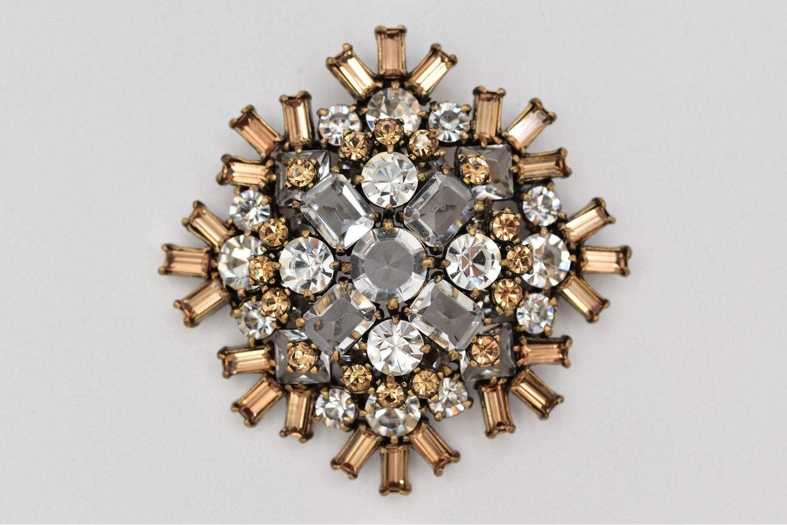 Decorative brooch with crystal-like stones on a light gray background
