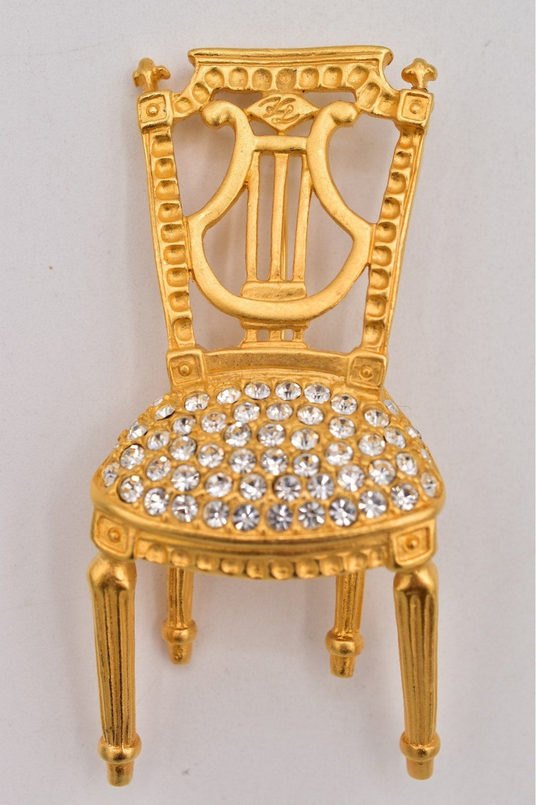 Gold chair with crystal embellishments on a gray background
