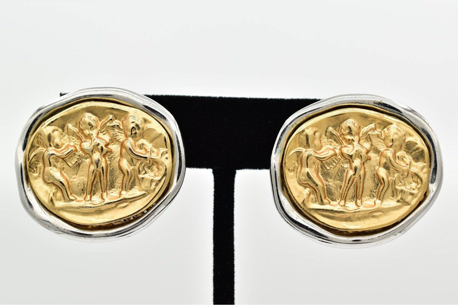 Gold cufflinks with classical design on a black band against a white background