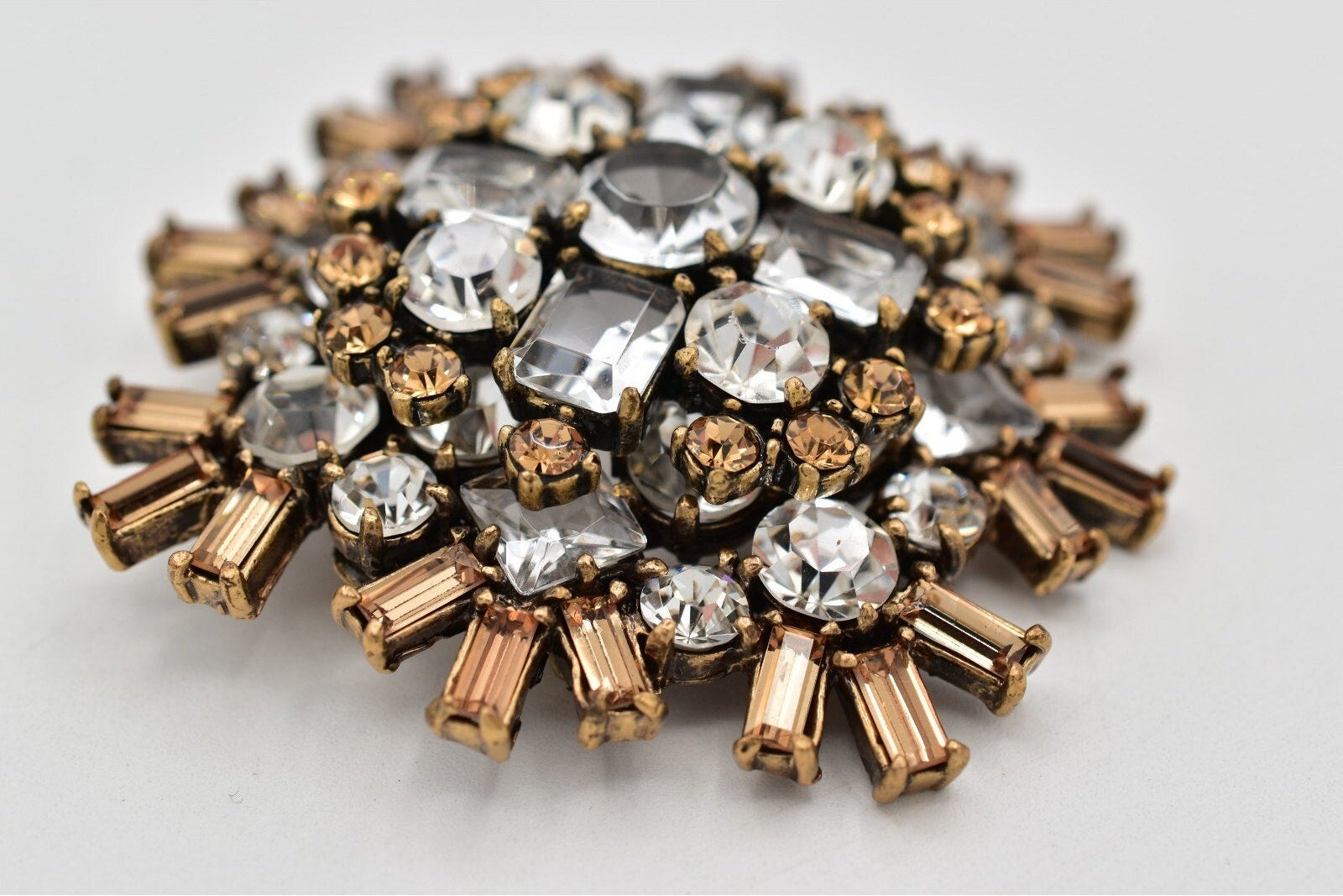 Decorative brooch with crystal-like stones on a light gray background